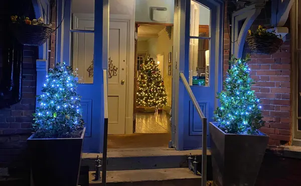 Crown and Castle front door with Christmas trees lit up